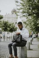 jovem empresário afro-americano esperando um táxi em uma rua foto