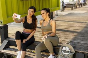 mulheres jovens em roupas esportivas tomando selfie com telefone celular após treinamento físico foto