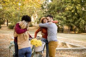 jovens multirraciais caminhando no parque de outono foto