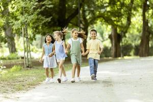 grupo de crianças asiáticas e caucasianas se divertindo no parque foto