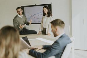 jovens empresários apresentando a estratégia do projeto mostrando ideias na lousa interativa no escritório foto