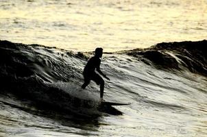 surfista de silhueta ao pôr do sol foto