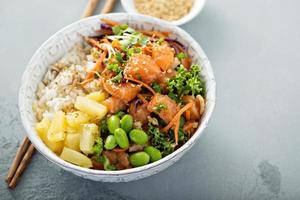 poke bowl com salmão cru, arroz e legumes foto