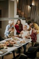 família comemorando o aniversário do avô com bolo e velas em casa foto