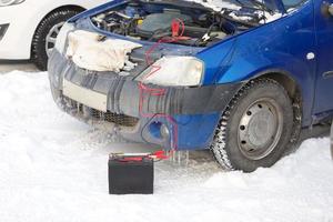 conectando fios de alta tensão à bateria do carro. carregando bateria descarregada de automóvel foto