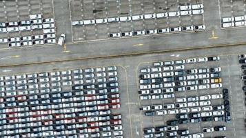 vista aérea do estoque de carros novos no estacionamento da fábrica. acima ver carros estacionados em uma fileira. indústria automobilística. negócio de logística. importar ou exportar carros novos no armazém. grande estacionamento no terminal portuário foto