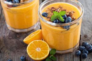 smoothie de laranja e manga com granola foto