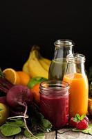 sucos de frutas e vegetais frescos com beterraba, frutas vermelhas e verduras foto