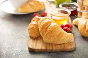 croissants recém-assados com mel e geléia foto