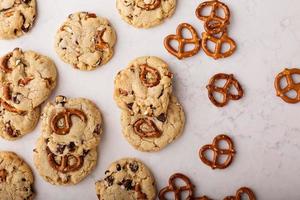 lascas de chocolate e biscoitos pretzels em uma mesa de mármore foto