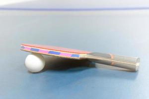 raquetes de ping pong e bolas na mesa foto