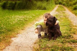menino com um cachorro andando no parque. criança brincando com o cachorro foto