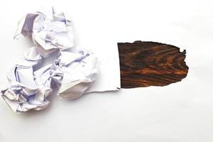 papéis amassados com uma folha de papel em branco sobre fundo de madeira foto