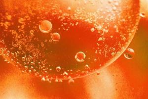 fundo laranja claro abstrato com círculos de óleo. bolhas de óleo de água fecham. fundo de bolhas de círculo ardente foto