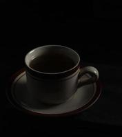 xícara de chá isolada em um fundo preto foto