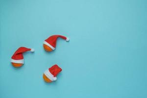 natal, ano novo azul elegante moldura plana com tangerinas em chapéus de papai noel. composição de férias de inverno. vista de cima. foto
