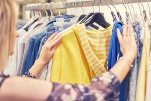 mulher feliz comprando roupas na loja foto