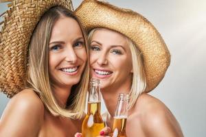 meninas festejando em chapéus e brindando bebidas foto