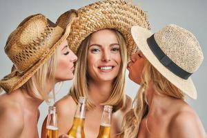 meninas festejando em chapéus e brindando bebidas foto