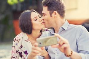 jovem casal namorando no parque e usando smartphones foto