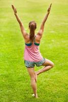 jovem mulher fazendo ioga no parque foto