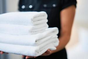empregada com toalhas limpas no quarto de hotel foto
