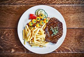 bife de churrasco de carne com batatas fritas foto