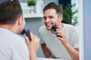 retrato de homem adulto fazendo a barba no banheiro foto