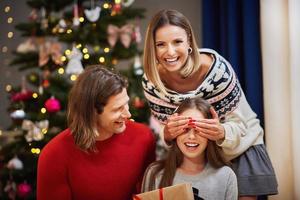 linda família com presentes debaixo da árvore de natal foto