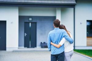 casal em frente a casa unifamiliar em área residencial moderna foto