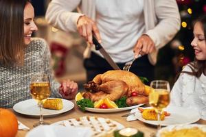 linda família comendo o jantar de natal em casa foto