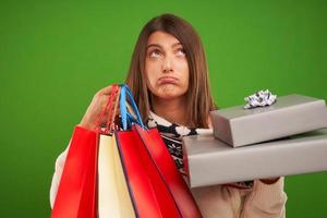 mulher feliz adulta comprando presentes de natal sobre fundo verde foto