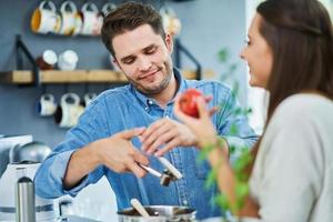 casal adulto cozinhando juntos em casa foto