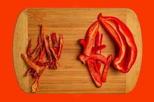 chips de pimenta vermelha seca kappia sweet bell, páprica e fatias de pimenta fresca em uma placa de cozinha de madeira. feche, copie o espaço. foto