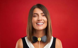 mulher morena atraente posando com gadgets de foto de ano novo sobre fundo vermelho