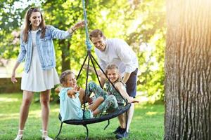 família alegre se divertindo no playground foto