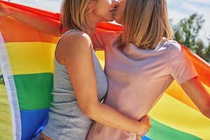 mulher vestindo bandeira lgbt ao ar livre. foto