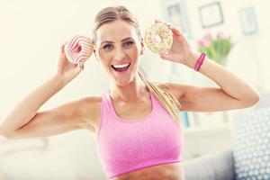 mulher desportiva com donuts após treino foto