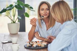 boas duas garotas adultas na casa comendo sushi foto