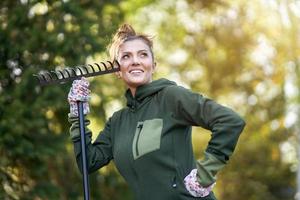 jovem mulher feliz com ferramentas de jardim trabalhando foto