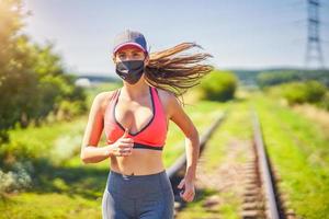 atleta feminina correndo com máscara na zona rural foto