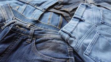 pilha de pares de jeans de vários tons de azul e tamanhos foto