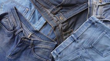 pilha de pares de jeans de vários tons de azul e tamanhos foto