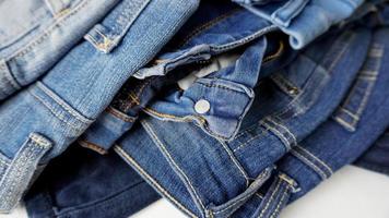 pilha de pares de jeans de vários tons de azul e tamanhos foto