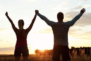 jovem casal correndo nas suberbs após o pôr do sol foto