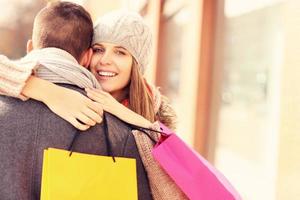 mulher feliz abraçando um homem enquanto fazia compras foto