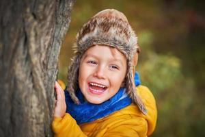 menino criança feliz brincando lá fora no outono foto