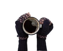 mãos femininas em luvas segurando uma xícara de café isolada foto