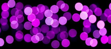 bokeh roxo abstrato sem foco em fundo preto. desfocado e desfocado muitas luzes redondas foto