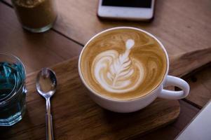 xícara de arte com leite com aroma de café na mesa de madeira relaxtime no café cafeteria foto